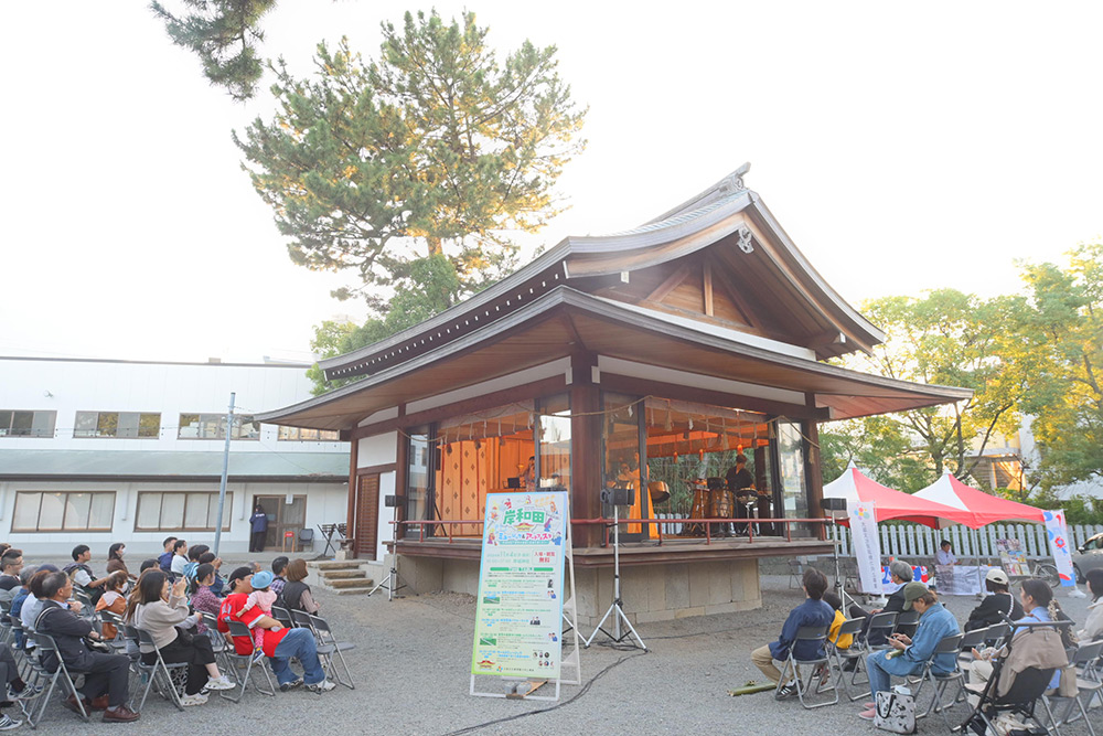 神楽殿での演奏と、観客ら
